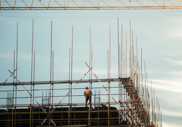 Silhouetted Grit: A Worker at Dusk Beneath the Blue Sky